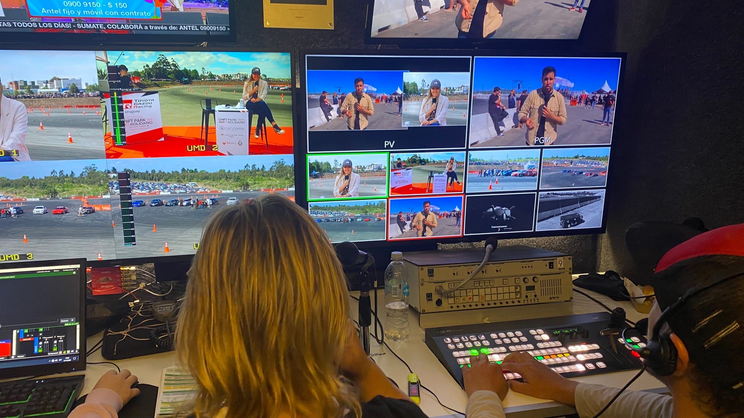 Dos integrantes del equipo frente a la mezcladora de video y a los monitores de la cabina de control durante la transmisión del Drift Park Solidario