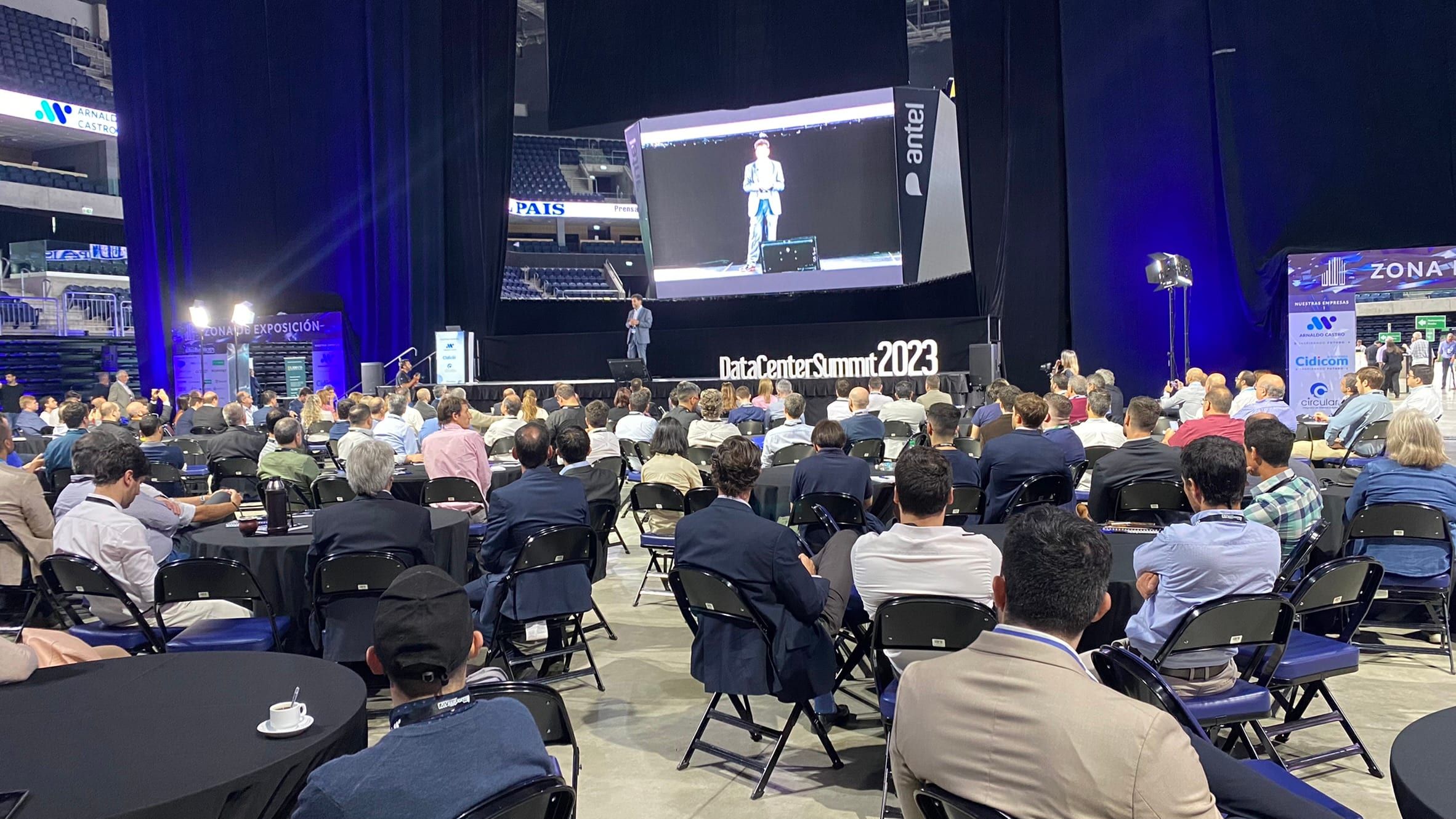 Exposición en el escenario del Data Center Summit 2023, con el orador en pantalla gigante y la platea llena