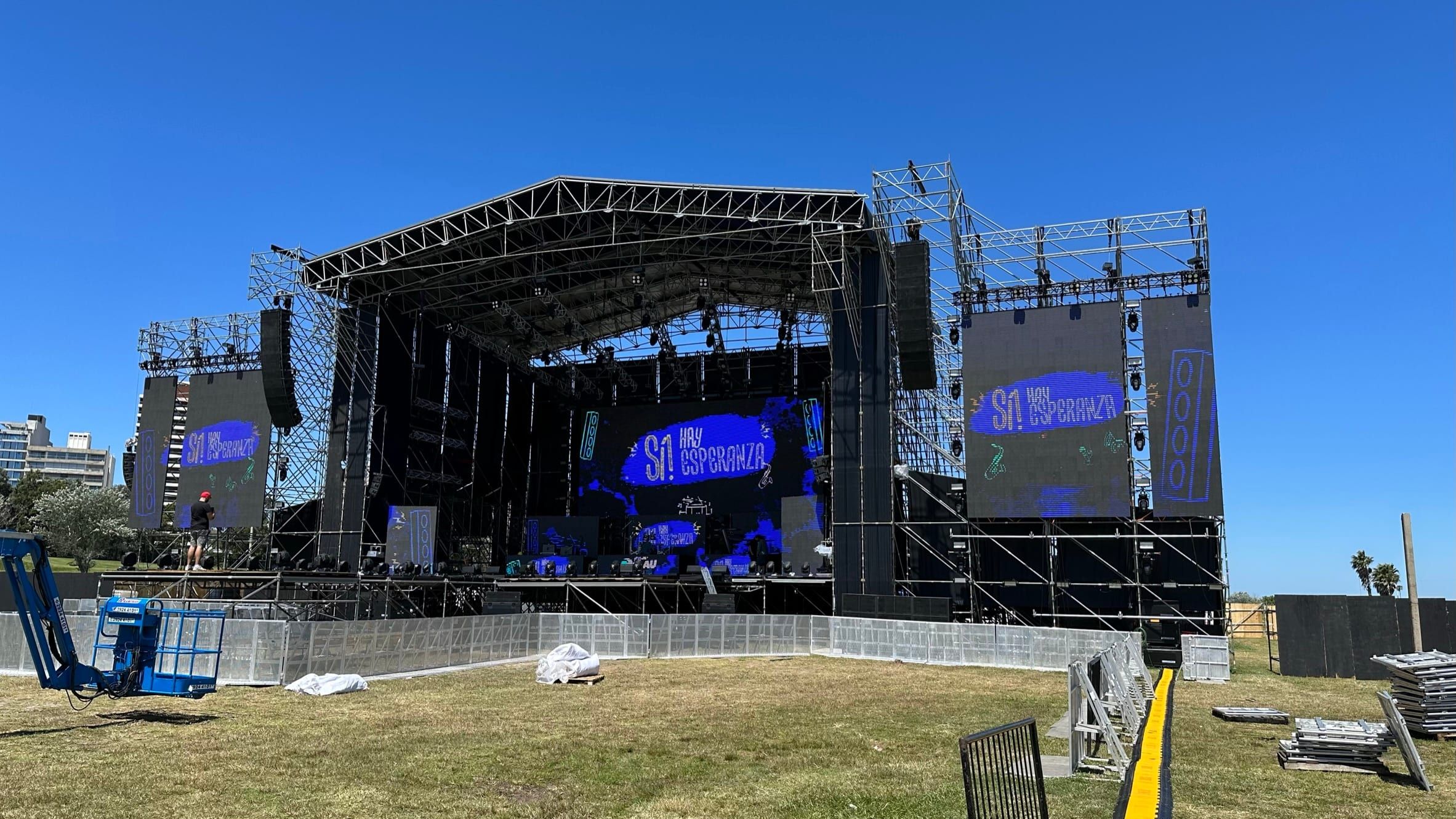 Escenario del Festival Palau Uruguay 2023 durante el montaje, de día, con pantallas con el lema «Sí, hay esperanza»