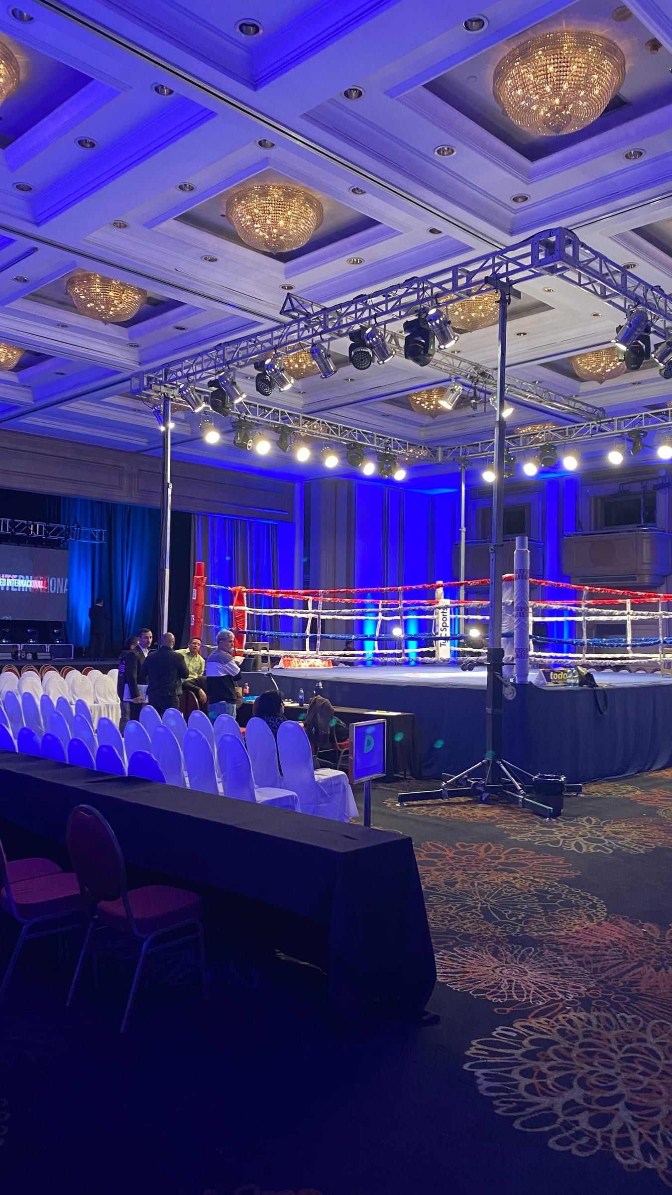 Salón del Radisson Victoria Plaza con el ring bajo una estructura de luces azules y las sillas para el público