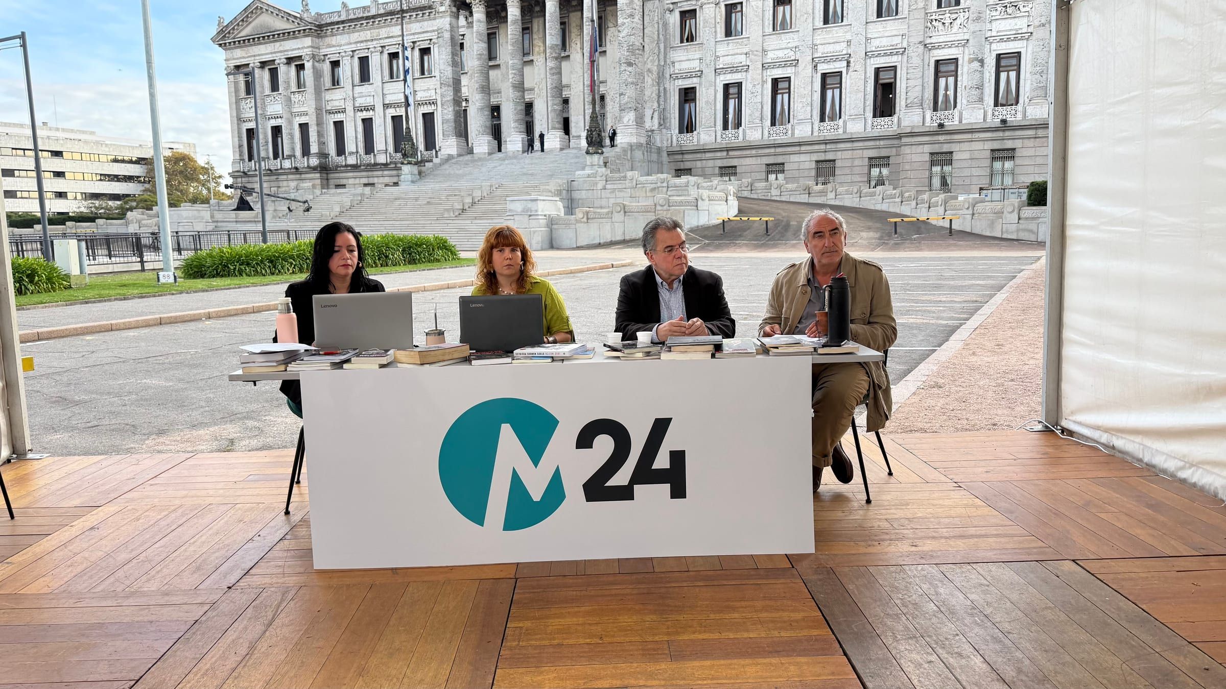 Cuatro panelistas en la mesa con el logo de M24, con el Palacio Legislativo al fondo de día