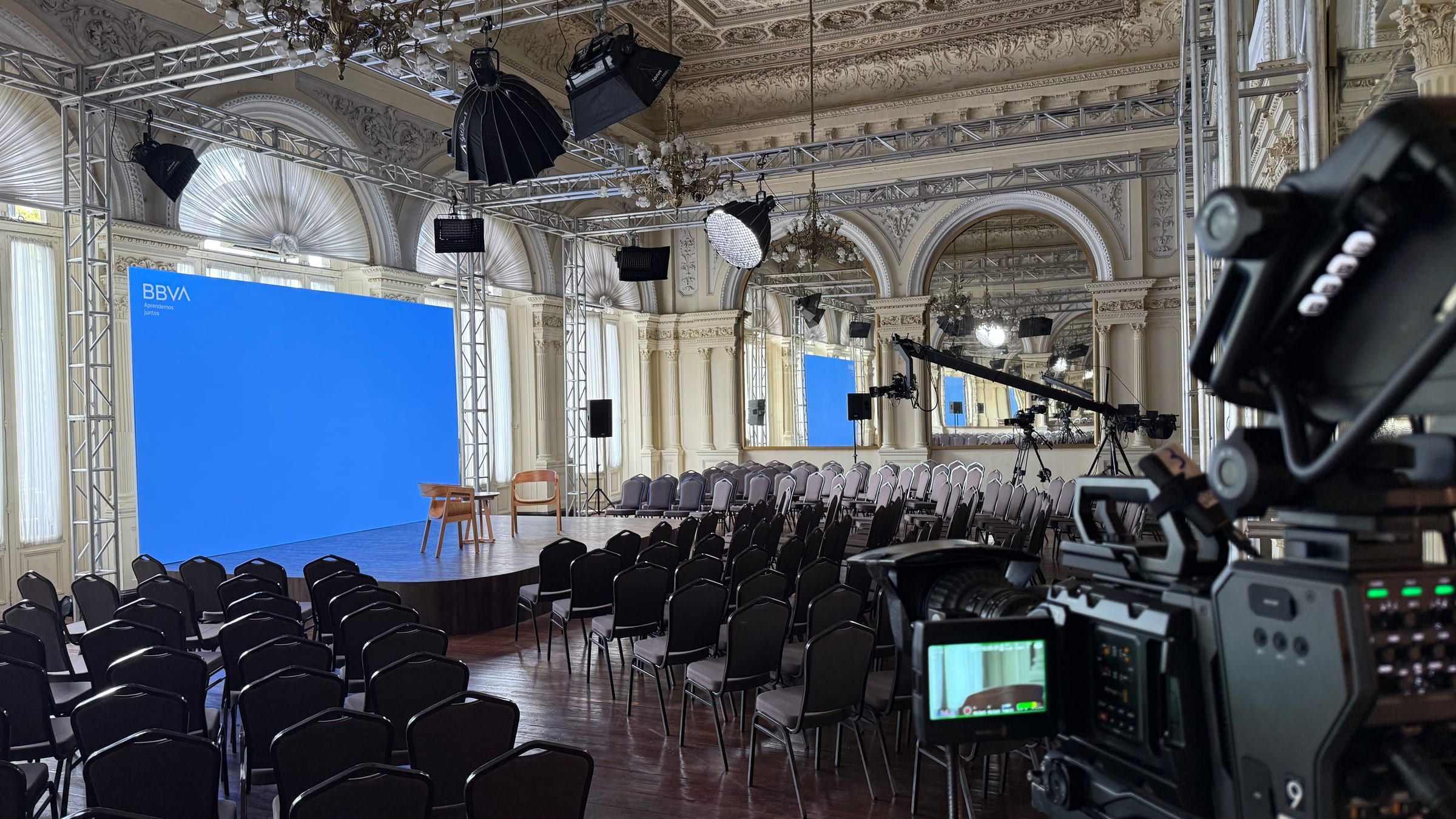 Cámara de video en primer plano y escenario con pantalla LED en el salón del evento