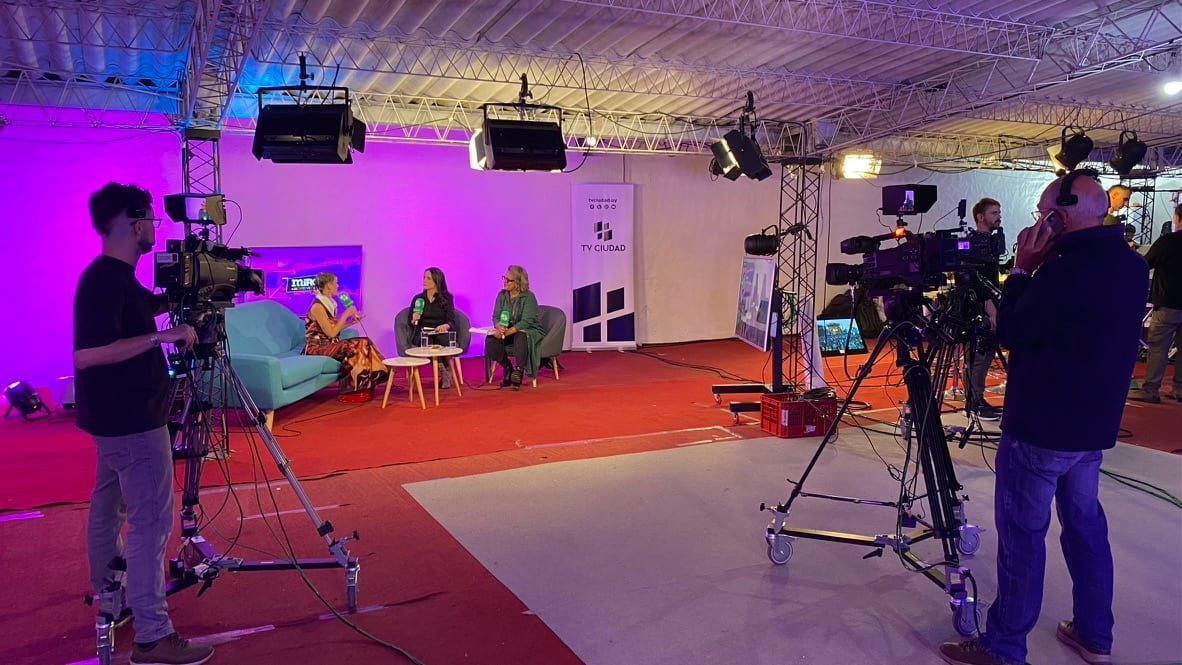 Dos camarógrafos con cámaras de hombro y pedestal ruedan una entrevista en el estudio instalado en el Cosquín Rock