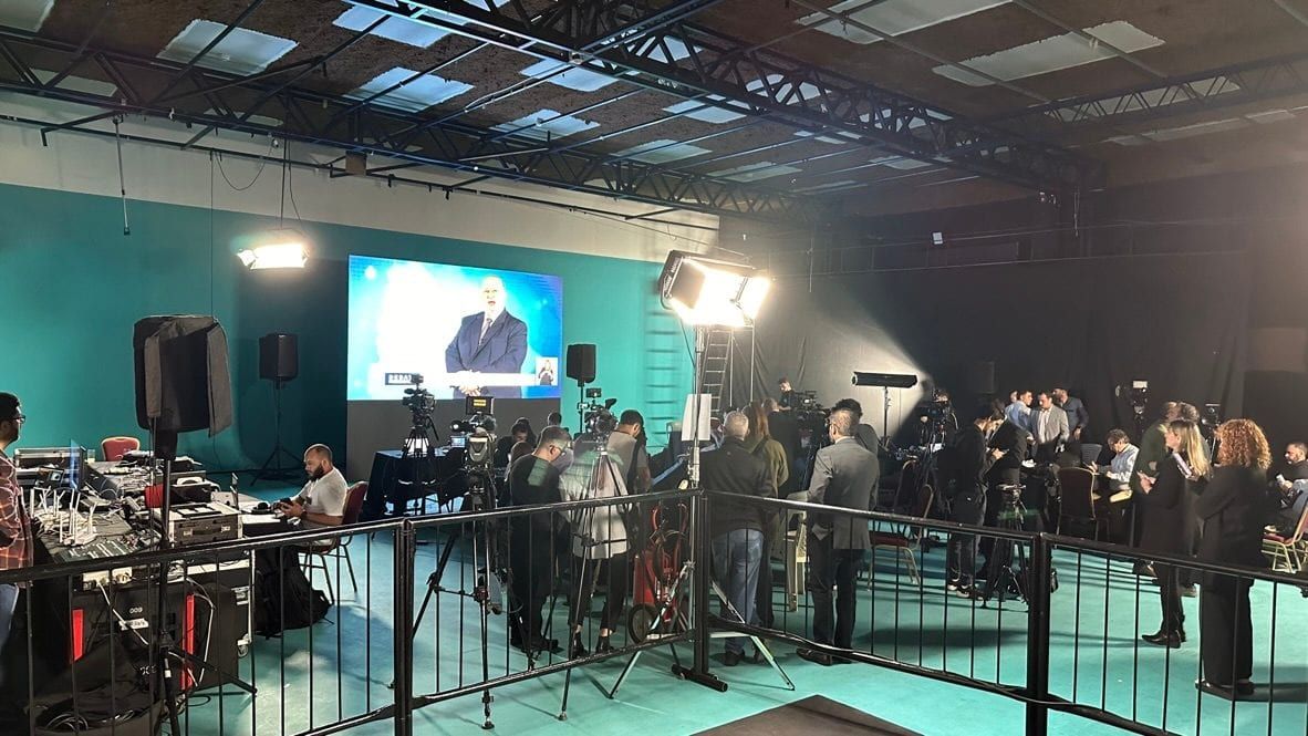 Estudio durante el debate presidencial, con el equipo técnico y la prensa detrás de la valla frente a la pantalla del debate.