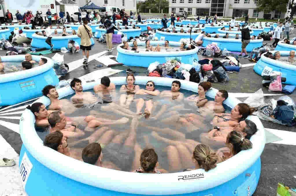 Participantes dentro de una piscina inflable con hielo, rodeada de otras piscinas, durante el Ice Challenge 2024